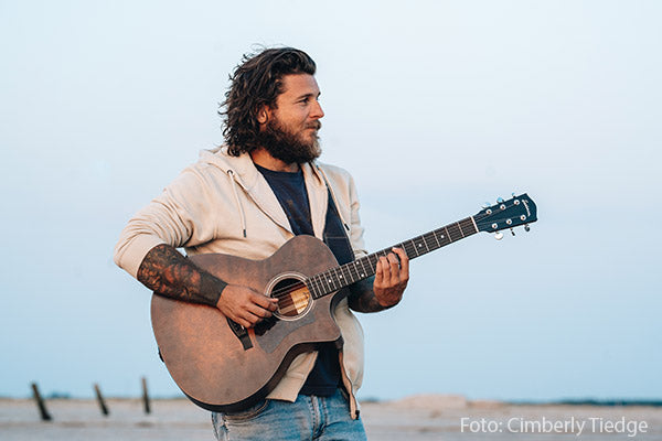 Rasmus Hoffmeister mit Gitarre am Strand Credit Cimberly Tiedge
