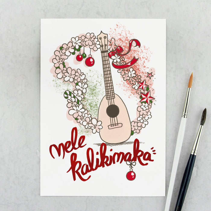 Weihnachtskarte mit Pineapple-Ukulele, umrahmt von einem weihntlichen Blumenkranz mit Kugeln und Schleife, darunter der Schriftzug Mele Kalikimaka 